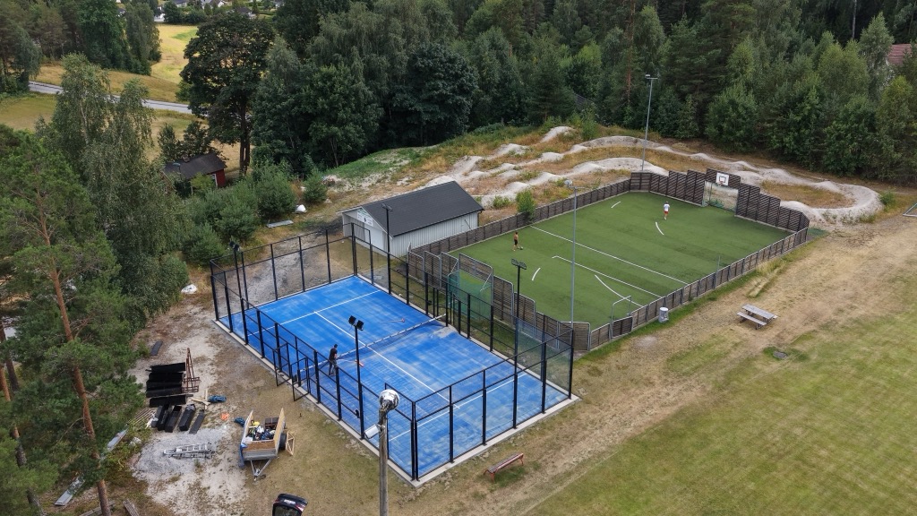 Padelbanen sett fra lufta med fotballbanen ved siden av